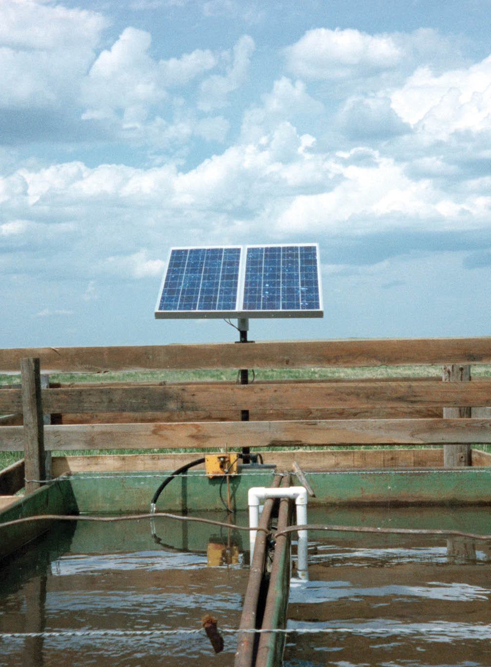 This solar-powered water pumping station is located on the Martin Ketterling Ranch, north of Heil, North Dakota.  The system has two Solarjack 50-watt panels and a Solarjack water pump and controller. Two Interstate marine batteries are used for backup pumping on cloudy days and at night, because of the small size of the water tanks. The system pumps around four gallons per minute, watering around 40 head of cattle.