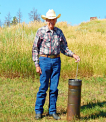 George Porter next to rusty metal rain gauge 