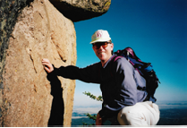 Robert Waggener on leaning on rock on top of mountain 