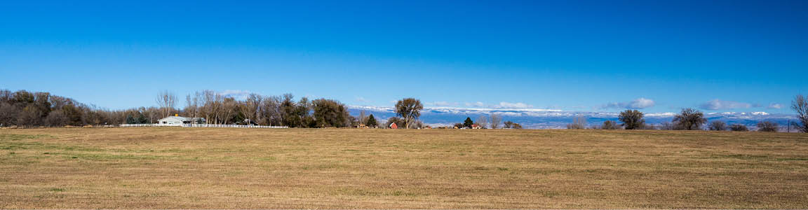 panoramic photo of ranch with mountains in background