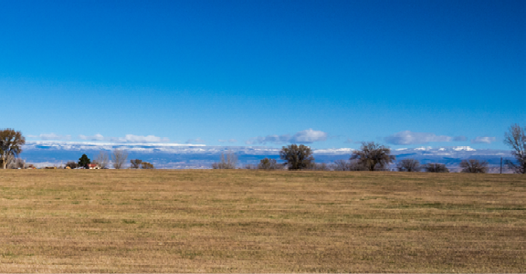 panoramic photo of ranch with mountains in background